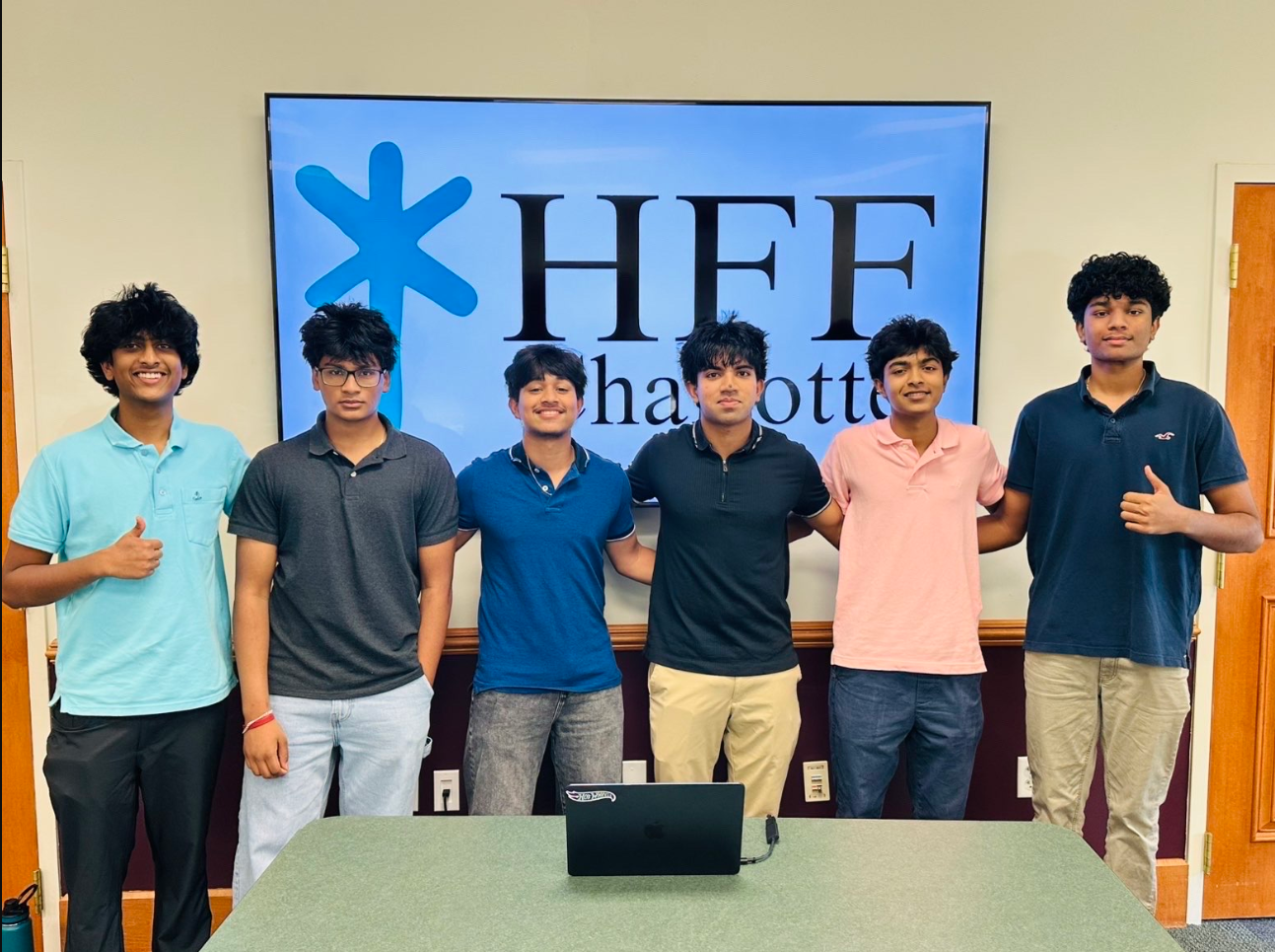 HFF student leadership team standing together in front of the HFF logo